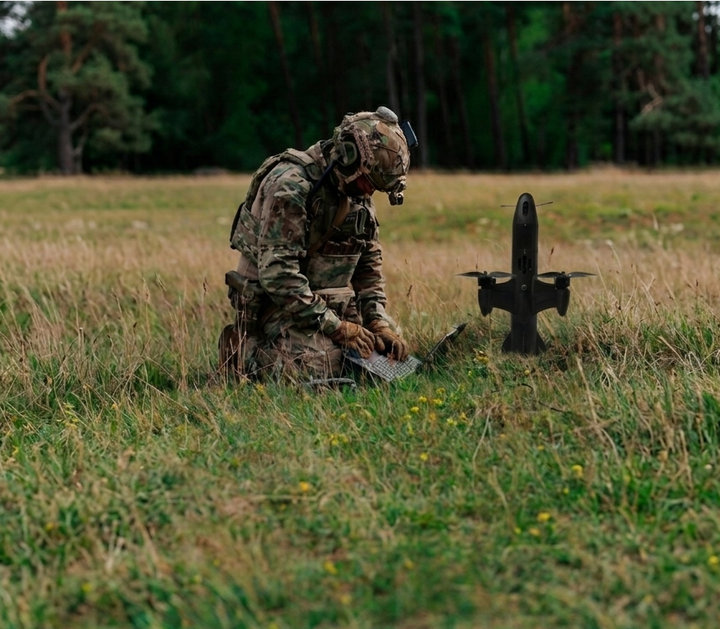 Operator preparing a ReaperRocket Beta-H07 interceptor for ground launch in tall grass